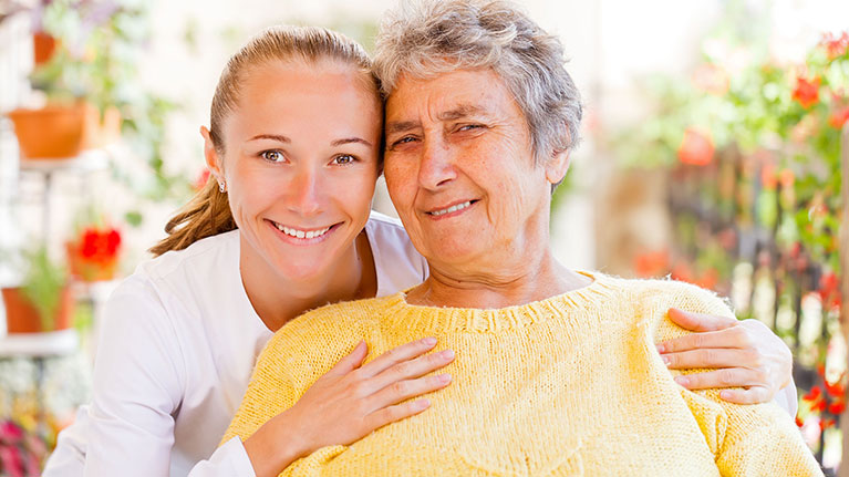 Grandmother and Granddaughter smiling looking into the camera.