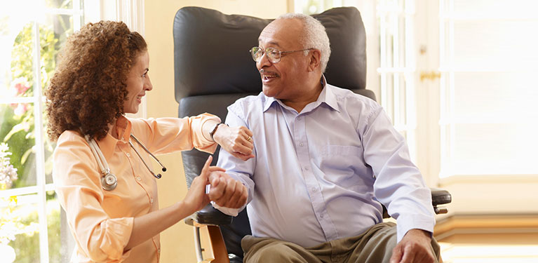 Nurse checking the pulse of patient in chair