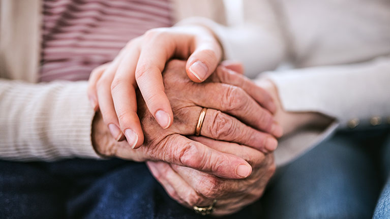 Senior hands holding younger hands.