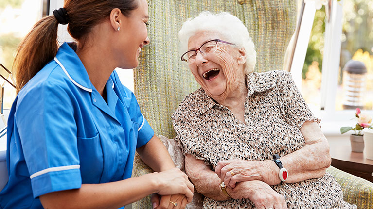 Female nurse smiling with senior patient. 
