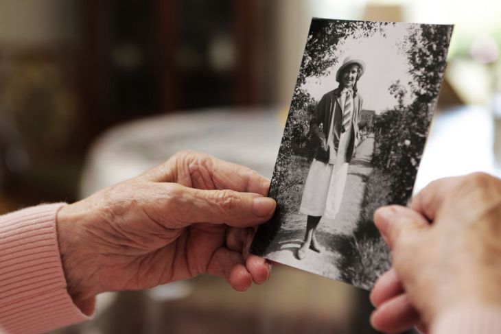 Elderly person holding an old photograph