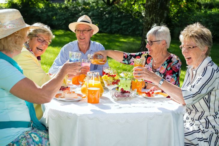 Seniors enjoying an outdoor meal on a summer day.