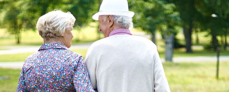 Senior couple walking around the grounds at Masonicare
